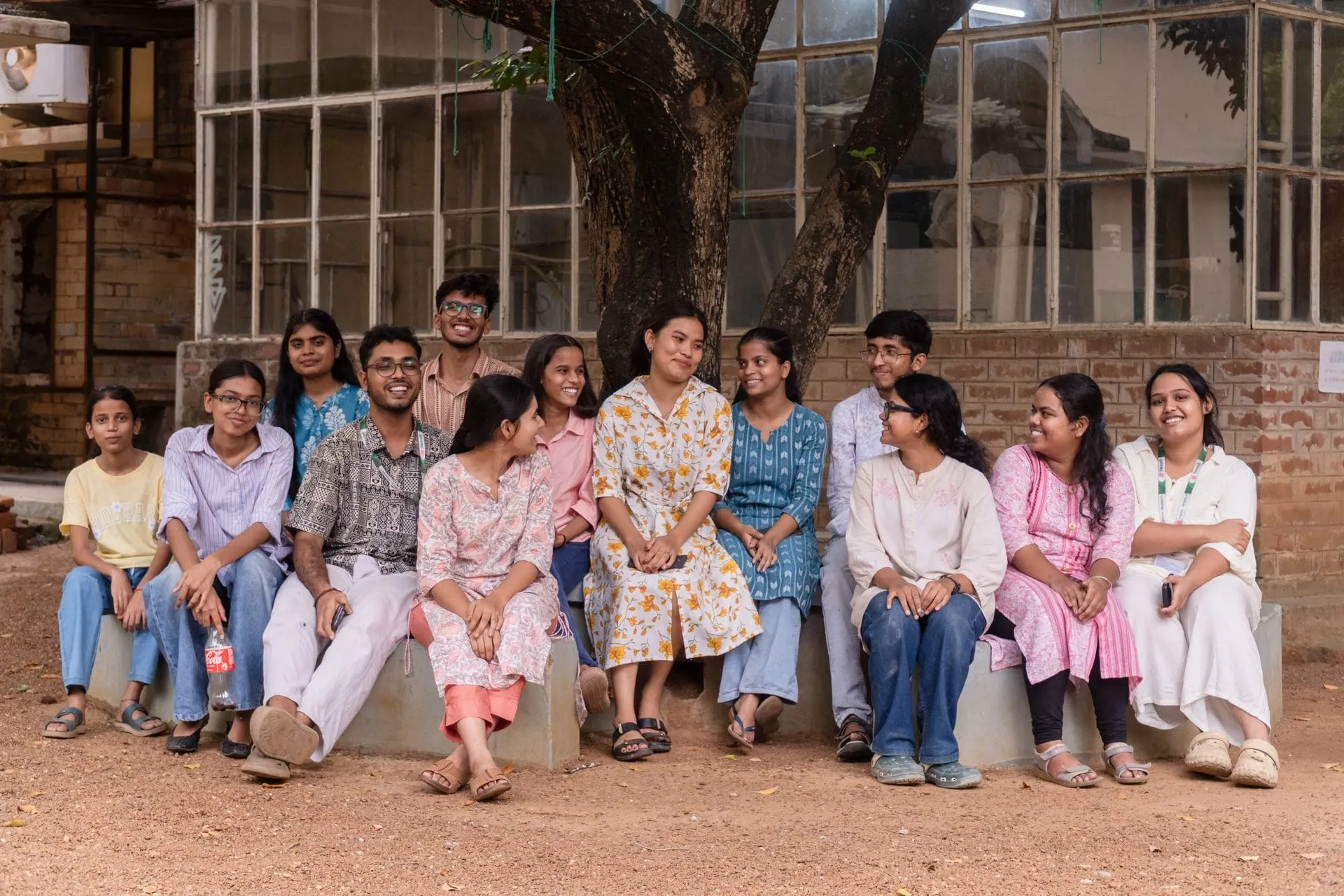 Group of Indian college students sitting together on a campus in Santiniketan